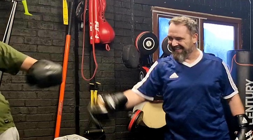 Two men boxing partners training together with pads at Boxing Fitness MK