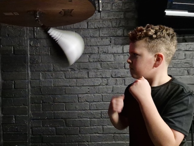 Teenage boxer practicing on speed bag at Boxing Fitness MK gym in Milton Keynes