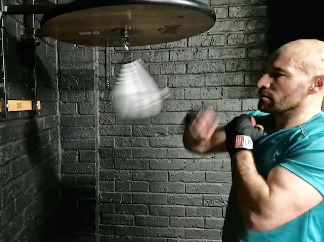 Athlete performing intense speed bag boxing training at Boxing Fitness MK gym