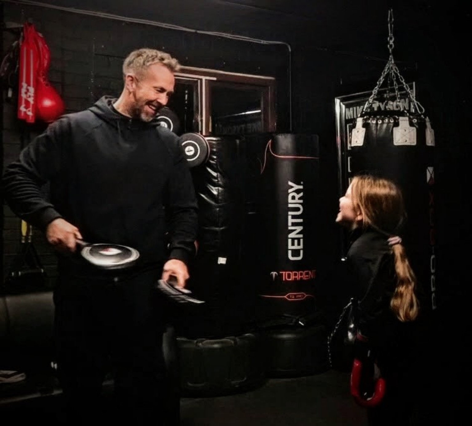 Boxing coach working one-to-one with a child during junior boxing coaching at The Boxing Room, Milton Keynes
