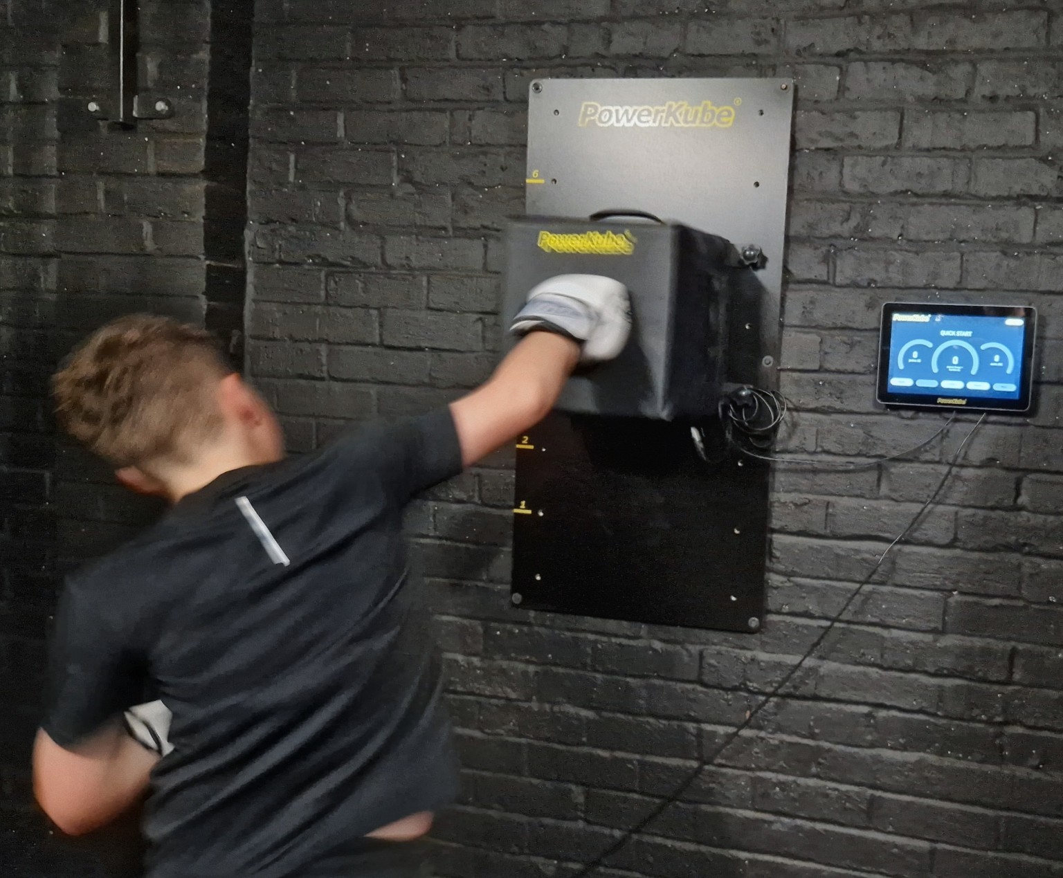 Young boxer testing punch power on the PowerKube during youth boxing coaching in Milton Keynes